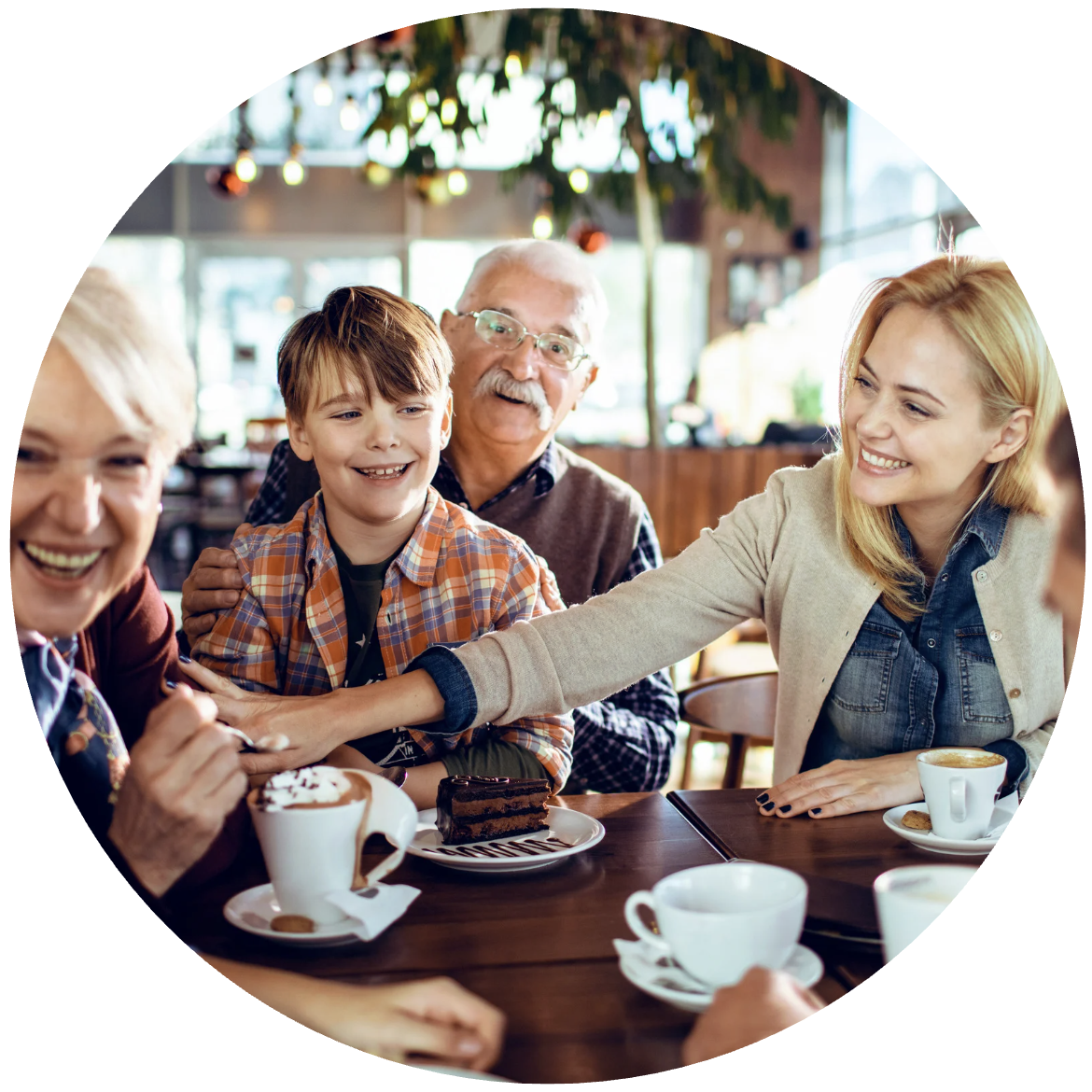 Familie am Tisch mit Kaffee und Kuchen